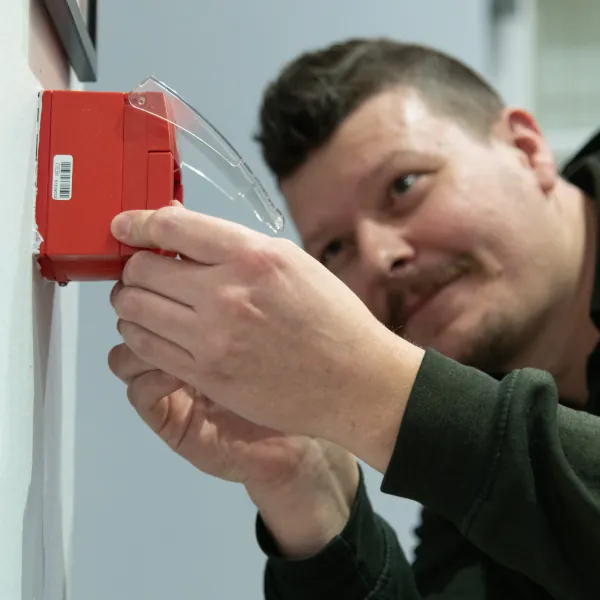 Photo of Ed fixing a fire alarm