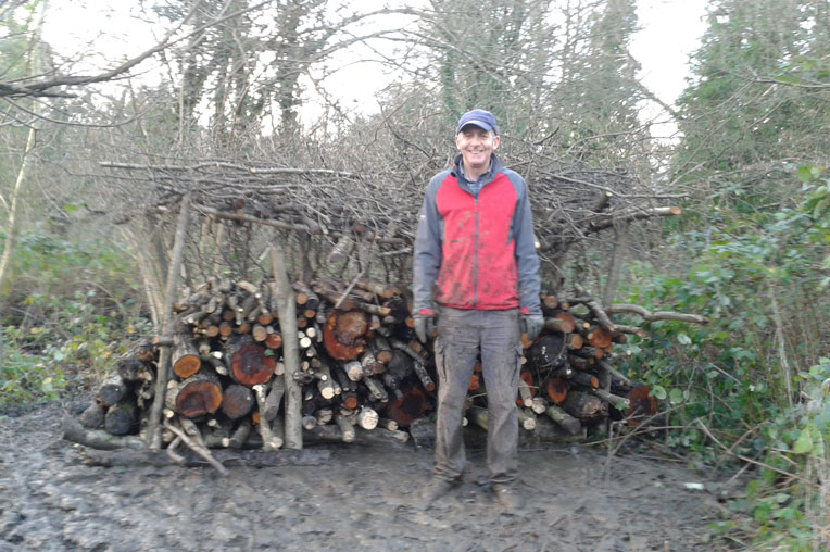 Picture of a volunteer making a wood store in the park