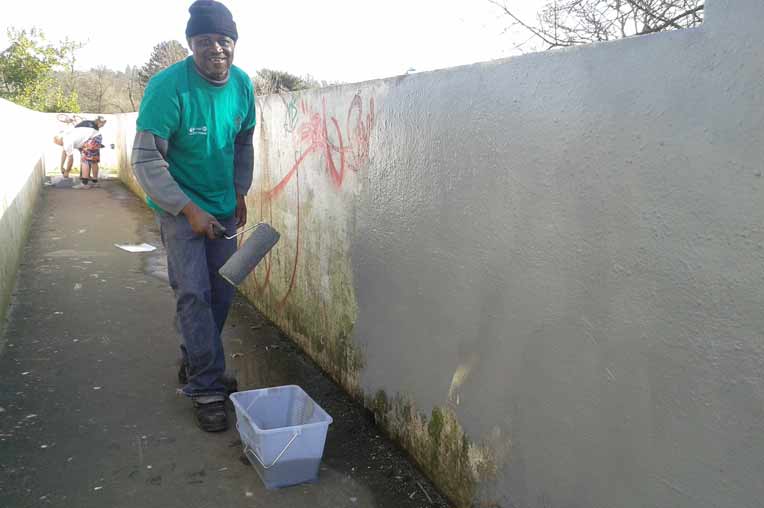 Picture of a volunteer painting the bridge in the park